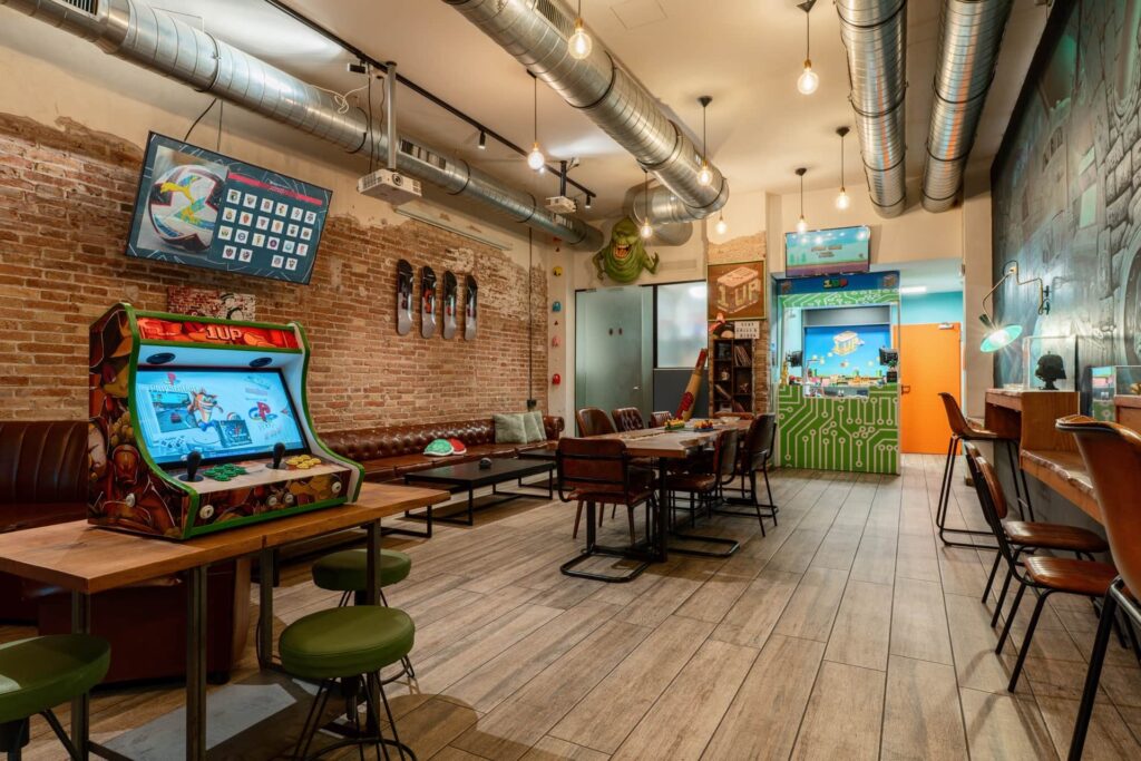 Arcade machine and lounge zone in social club 1UP Barcelona
