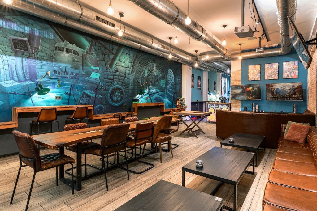Main room of 1UP weed club with large table and comic-style mural