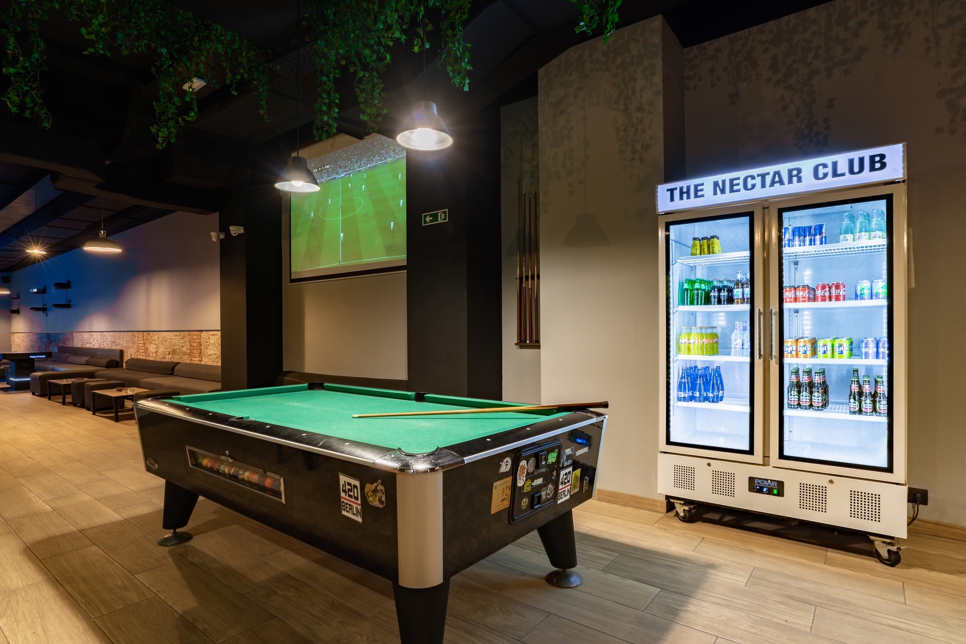 Billiard table and refrigerator with drinks in the Nectar club bcn